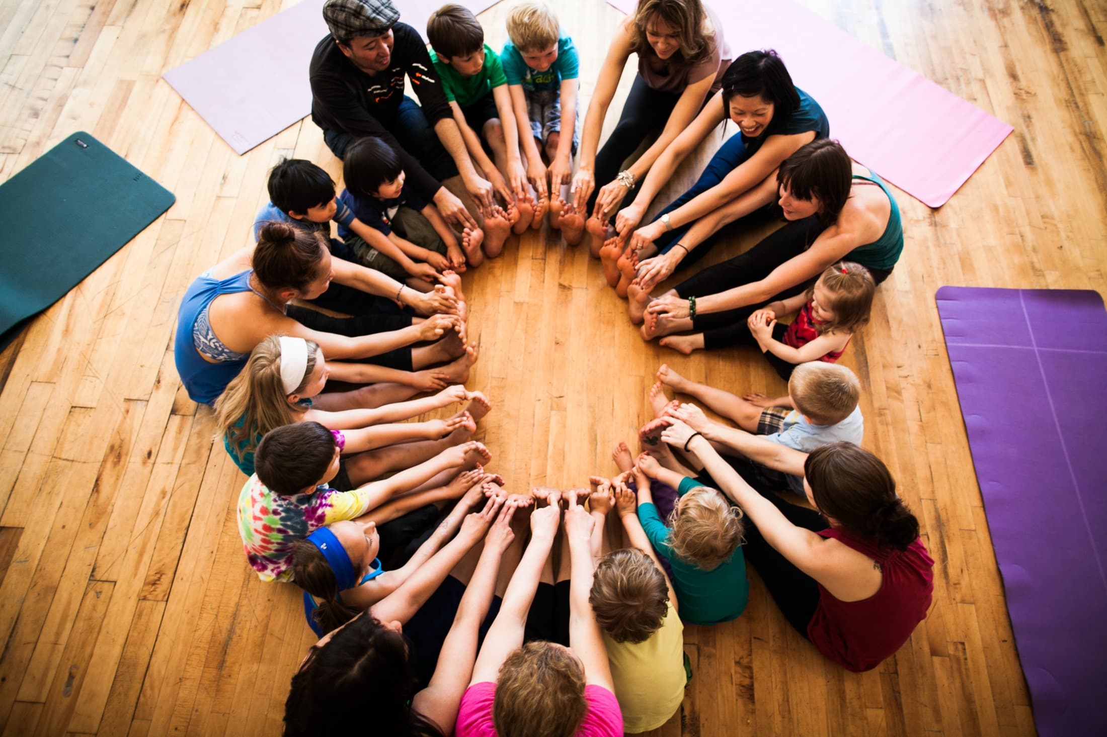 Children and adults making a feet circle in Rainbow Yoga