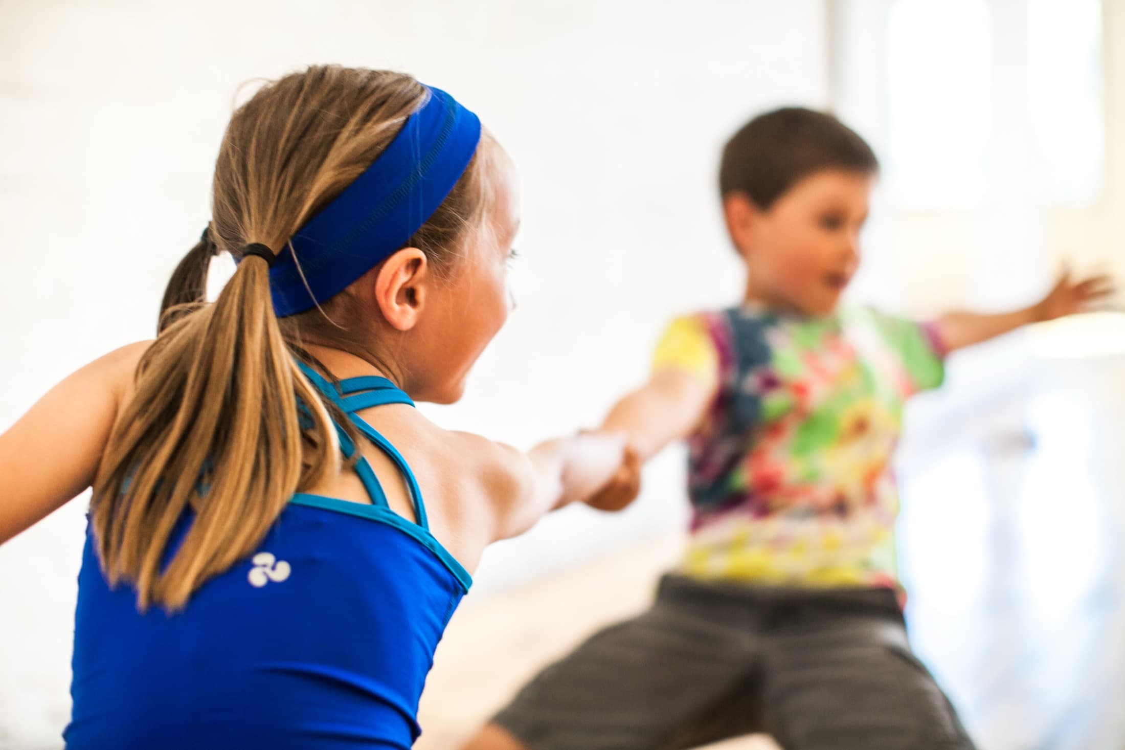 Children holding hands in a partner Rainbow Yoga activity